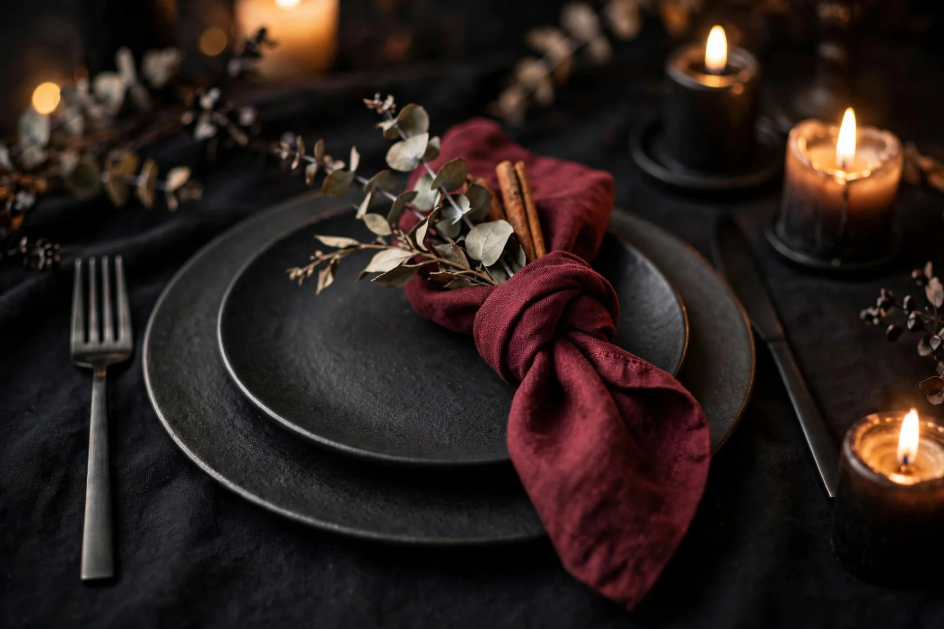 Layered Halloween place setting with black charger and burgundy napkin